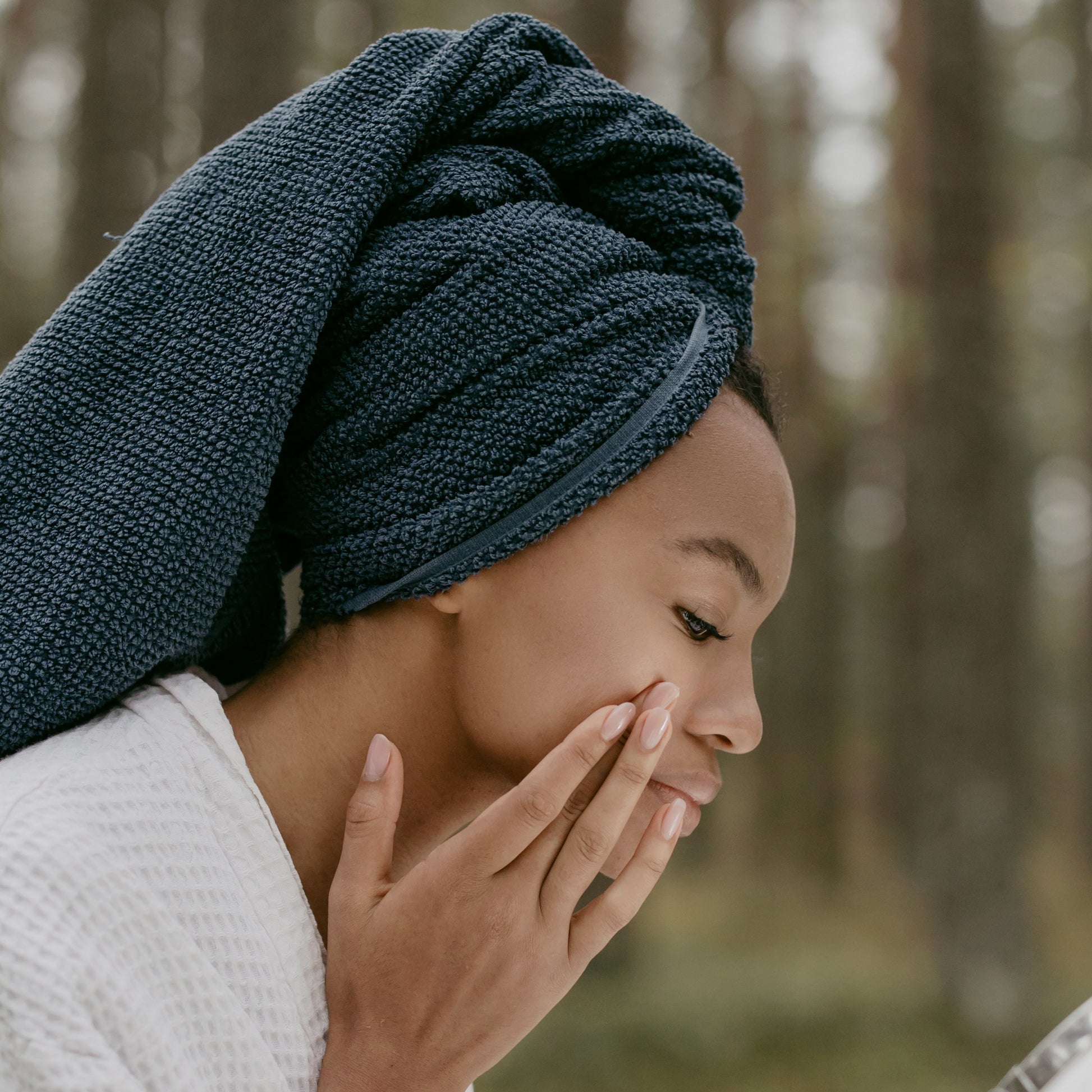 junge Frau mit Handtuch-Turban bei ihrer Pflegeroutine